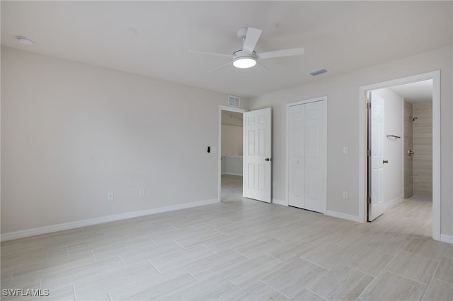 unfurnished bedroom featuring a closet, ensuite bathroom, baseboards, and visible vents