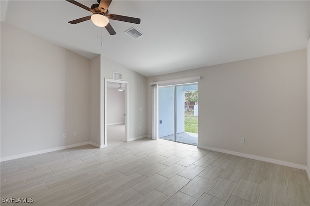 unfurnished room with baseboards, visible vents, ceiling fan, and vaulted ceiling
