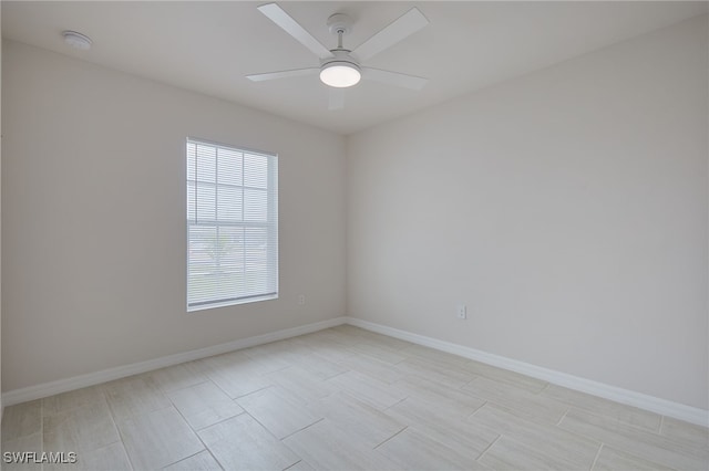 unfurnished room with a ceiling fan and baseboards