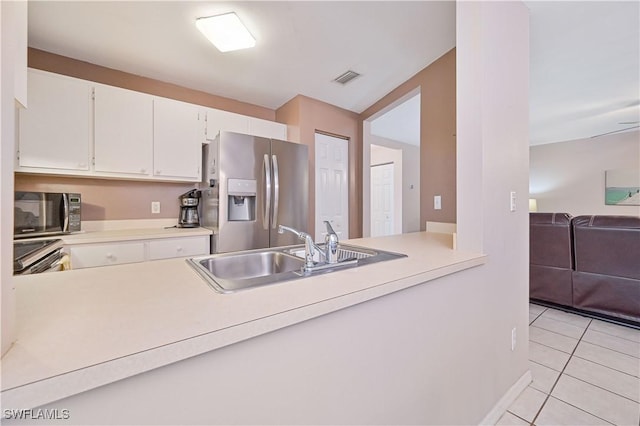 kitchen with light countertops, light tile patterned floors, stainless steel appliances, a sink, and visible vents