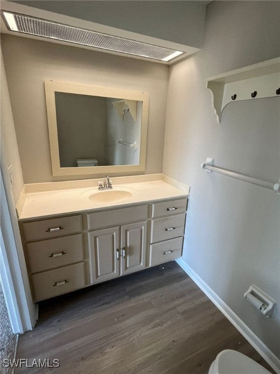 6824 Sandtrap Dr Unit 4, Fort Myers, FL 33919 - half bathroom with toilet, vanity, baseboards, and wood finished floors