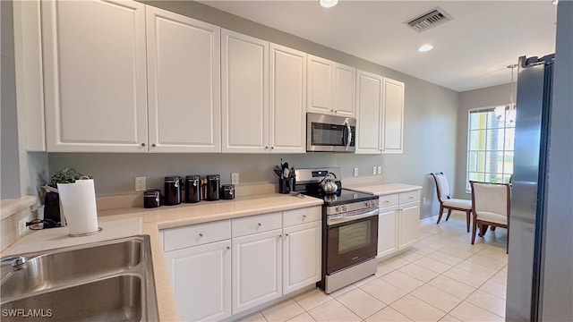 14512 Abaco Lakes Dr Unit 103, Fort Myers, FL 33908 - kitchen with visible vents, white cabinets, and appliances with stainless steel finishes