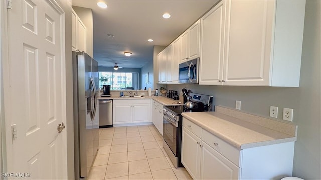 14512 Abaco Lakes Dr Unit 103, Fort Myers, FL 33908 - kitchen featuring light tile patterned flooring, white cabinetry, a sink, and appliances with stainless steel finishes