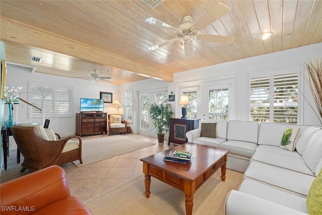 living area with light tile patterned floors, visible vents, beamed ceiling, ceiling fan, and wood ceiling