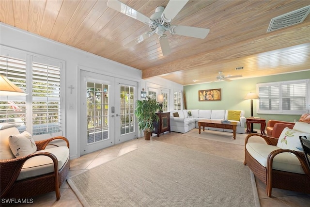 living area with french doors, light tile patterned floors, wood ceiling, visible vents, and a ceiling fan