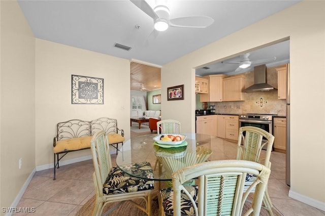 dining space with baseboards, visible vents, ceiling fan, and light tile patterned floors