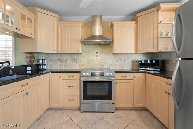 kitchen with tasteful backsplash, stainless steel appliances, light brown cabinetry, a sink, and wall chimney exhaust hood