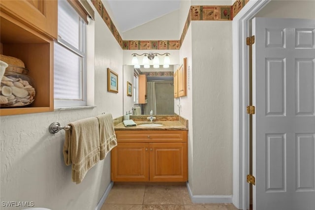 bathroom with a shower with door, baseboards, vaulted ceiling, and vanity
