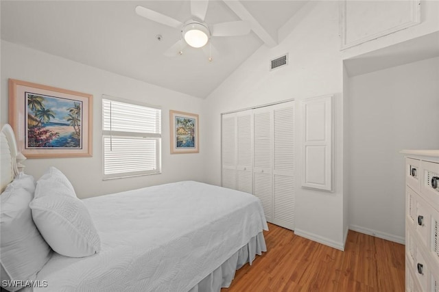 bedroom with a closet, lofted ceiling with beams, visible vents, baseboards, and light wood-type flooring