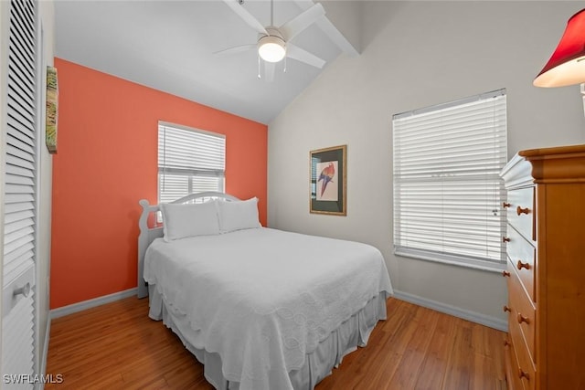 bedroom with baseboards, vaulted ceiling, a ceiling fan, and light wood finished floors