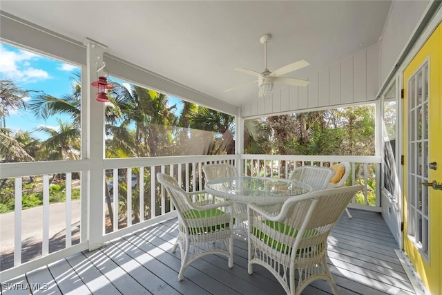 sunroom / solarium featuring outdoor dining area and a ceiling fan