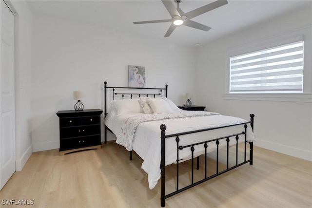 bedroom featuring baseboards, light wood-style flooring, and a ceiling fan