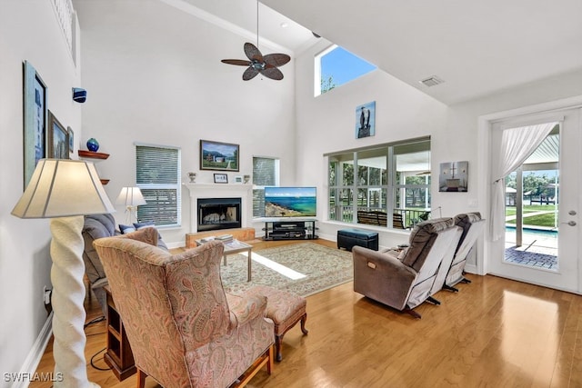 17150 Scout Camp Rd, Alva, FL 33920 - living room with visible vents, wood finished floors, a fireplace with raised hearth, and a ceiling fan