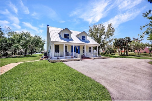 17150 Scout Camp Rd, Alva, FL 33920 - view of front of house with central AC unit, a porch, a front lawn, and metal roof