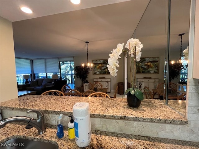 3661 Wild Pines Dr Unit 205, Bonita Springs, FL 34134 - kitchen with a sink, a chandelier, open floor plan, and stone countertops