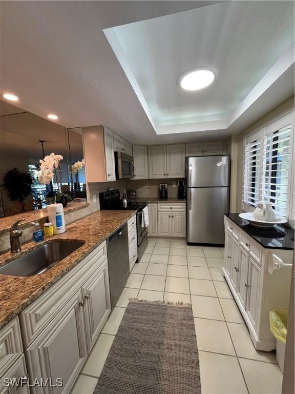 3661 Wild Pines Dr Unit 205, Bonita Springs, FL 34134 - kitchen with light tile patterned flooring, a tray ceiling, appliances with stainless steel finishes, and a sink