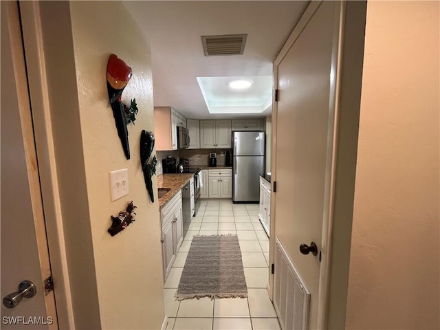 3661 Wild Pines Dr Unit 205, Bonita Springs, FL 34134 - kitchen with stainless steel appliances, light tile patterned flooring, visible vents, and a raised ceiling