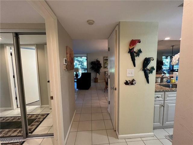 3661 Wild Pines Dr Unit 205, Bonita Springs, FL 34134 - hall featuring light tile patterned floors, baseboards, and a sink