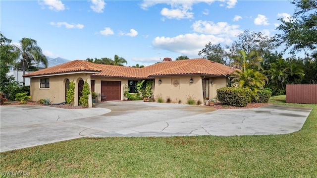 7090 Hendry Creek Dr, Fort Myers, FL 33908 - mediterranean / spanish-style house with a tile roof, concrete driveway, stucco siding, a front yard, and a garage