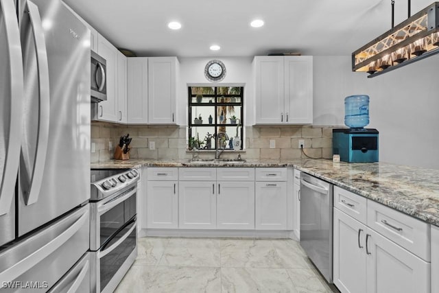 7090 Hendry Creek Dr, Fort Myers, FL 33908 - kitchen with white cabinetry, a sink, stainless steel appliances, and backsplash