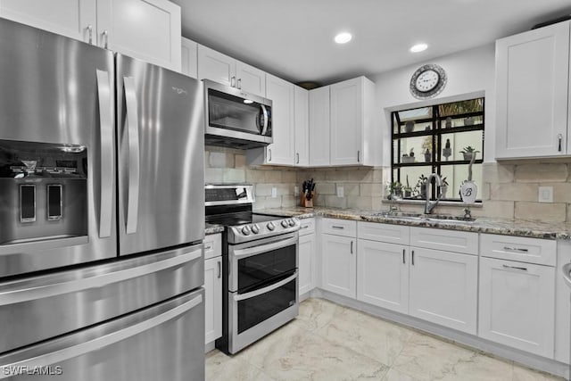 7090 Hendry Creek Dr, Fort Myers, FL 33908 - kitchen featuring decorative backsplash, marble finish floor, a sink, light stone counters, and appliances with stainless steel finishes
