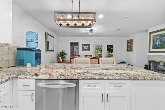 7090 Hendry Creek Dr, Fort Myers, FL 33908 - kitchen featuring stainless steel dishwasher, white cabinets, light stone countertops, and french doors