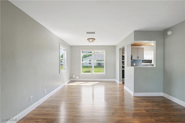 6070 Lacota Ave, Fort Myers, FL 33905 - unfurnished living room featuring wood finished floors, baseboards, and visible vents