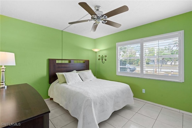 bedroom with light tile patterned floors, baseboards, and a ceiling fan