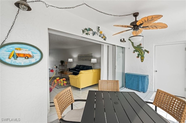 dining space with ceiling fan and tile patterned flooring