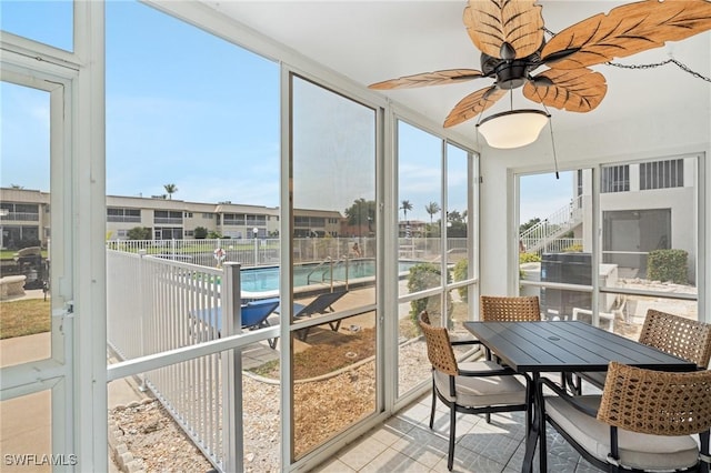 sunroom with ceiling fan and outdoor dining space