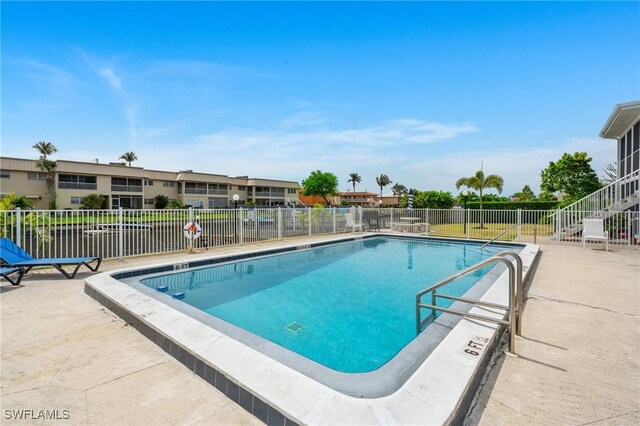 pool featuring fence and a patio area