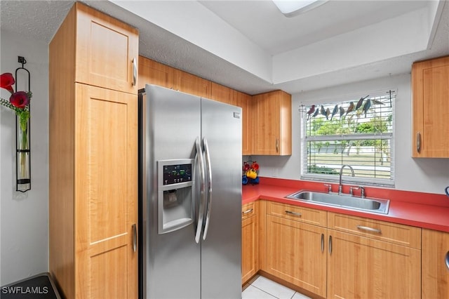 kitchen with light tile patterned floors, a sink, and stainless steel fridge with ice dispenser