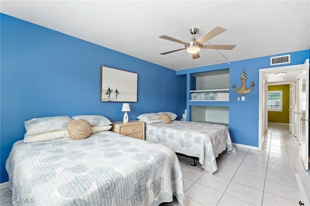 tiled bedroom featuring baseboards, visible vents, a ceiling fan, and a textured ceiling