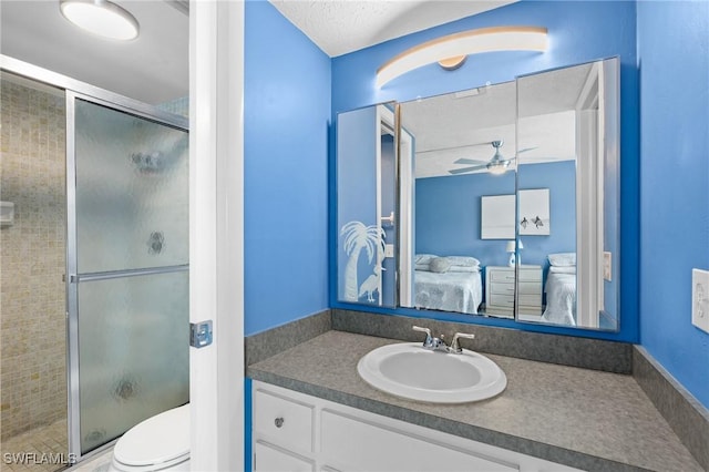 ensuite bathroom featuring toilet, vanity, a ceiling fan, a stall shower, and ensuite bath