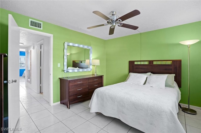 bedroom featuring light tile patterned flooring, a textured ceiling, visible vents, and ceiling fan