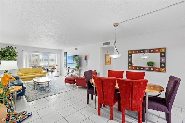 dining space featuring light tile patterned flooring, a textured ceiling, and visible vents