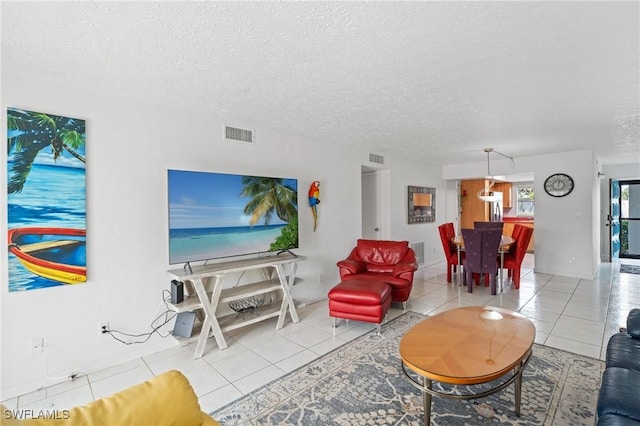 living room with tile patterned floors, a textured ceiling, and visible vents