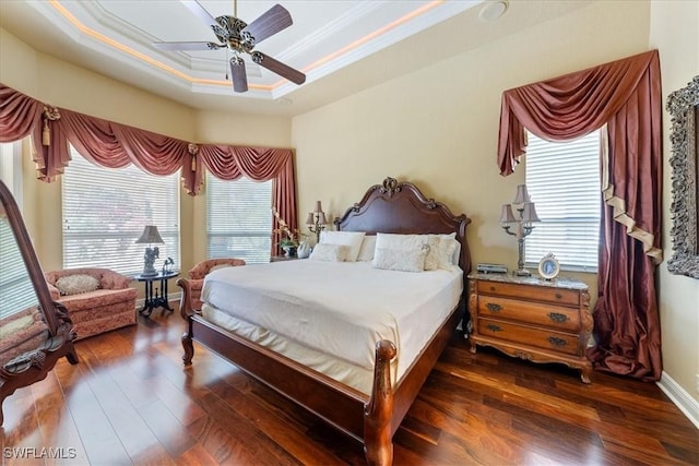 bedroom featuring a raised ceiling, ornamental molding, ceiling fan, and dark wood finished floors