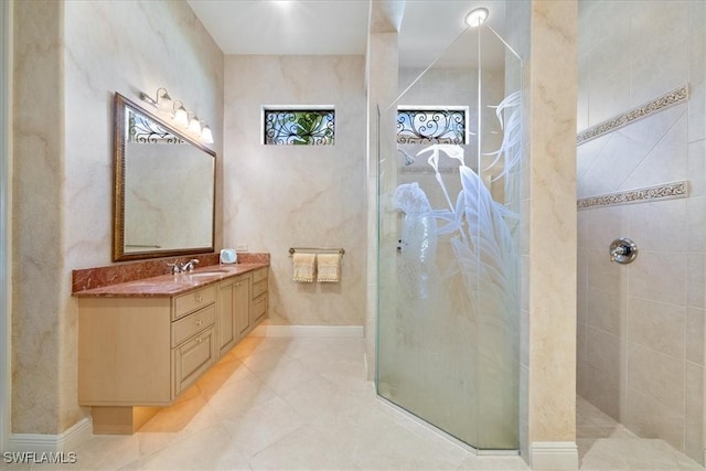 full bathroom with tile patterned floors, tiled shower, and vanity