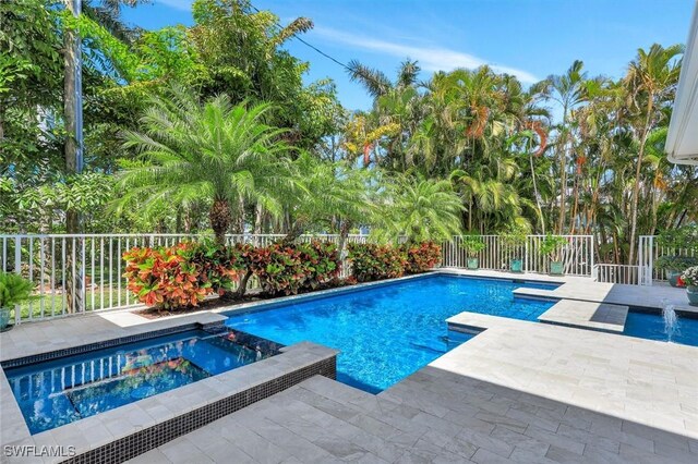 view of swimming pool featuring a pool with connected hot tub, a fenced backyard, and a patio area