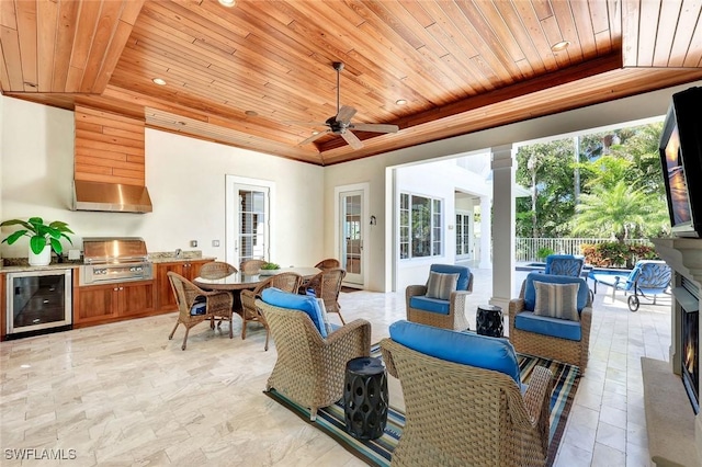 view of patio with wine cooler, outdoor dining area, an outdoor hangout area, and area for grilling