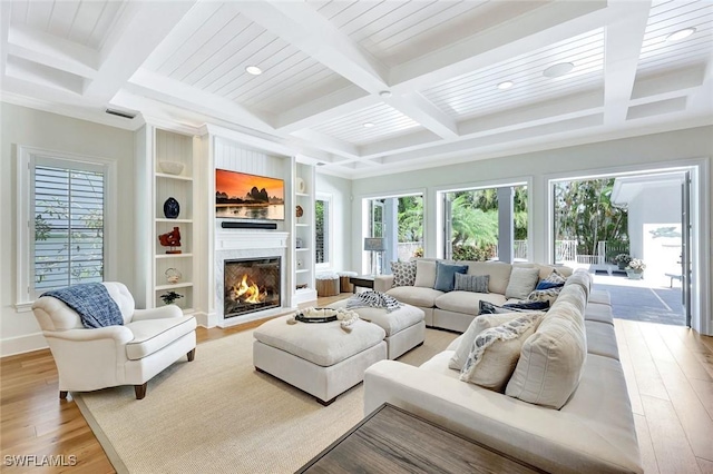 living area with light wood-style flooring, coffered ceiling, a fireplace, and beamed ceiling
