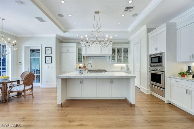 kitchen with visible vents, light wood-style floors, a chandelier, appliances with stainless steel finishes, and a warming drawer
