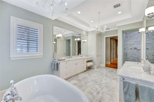 full bathroom with a freestanding tub, recessed lighting, two vanities, a chandelier, and a sink