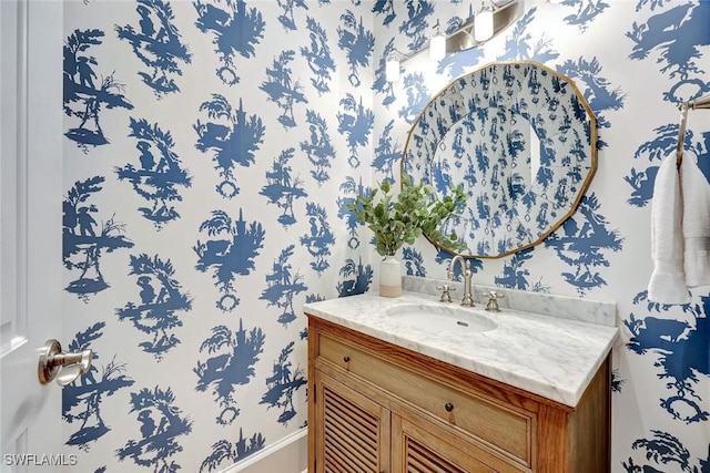 bathroom with wallpapered walls and vanity