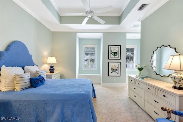 bedroom with visible vents, crown molding, a tray ceiling, and light colored carpet