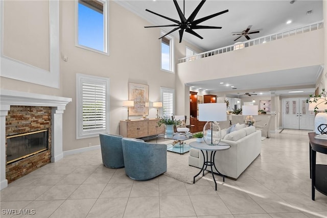 11476 Quail Village Way, Naples, FL 34119 - living room with a ceiling fan, healthy amount of natural light, a glass covered fireplace, crown molding, and a towering ceiling