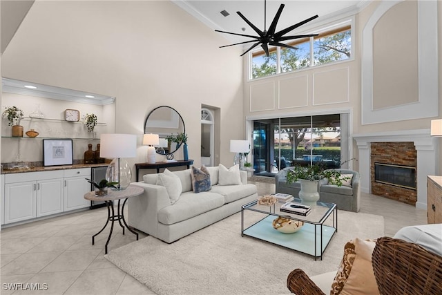 11476 Quail Village Way, Naples, FL 34119 - living area with ornamental molding, a towering ceiling, a stone fireplace, light tile patterned floors, and ceiling fan
