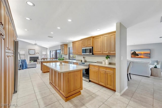 28389 Verde Ln, Bonita Springs, FL 34135 - kitchen with stainless steel appliances, open floor plan, light countertops, vaulted ceiling, and a center island