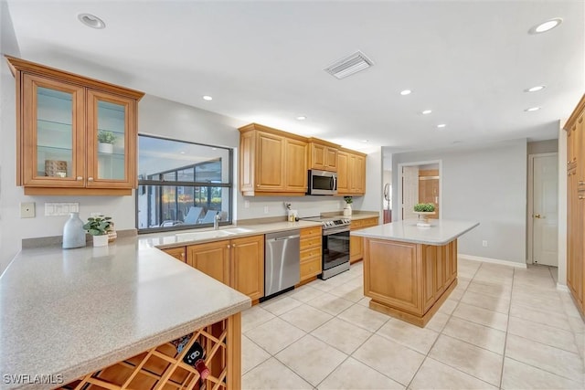 28389 Verde Ln, Bonita Springs, FL 34135 - kitchen featuring appliances with stainless steel finishes, light countertops, a kitchen island, recessed lighting, and light tile patterned floors
